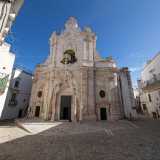 Raggiungiamo la chiesa nella parte nord del centro storico, l� dove in un piccolo slargo di via Santa Maria svetta la sua facciata in pietra bianca restaurata nel 2008, coperta per� da un�invadente luminaria non rimossa dopo una recente sagra